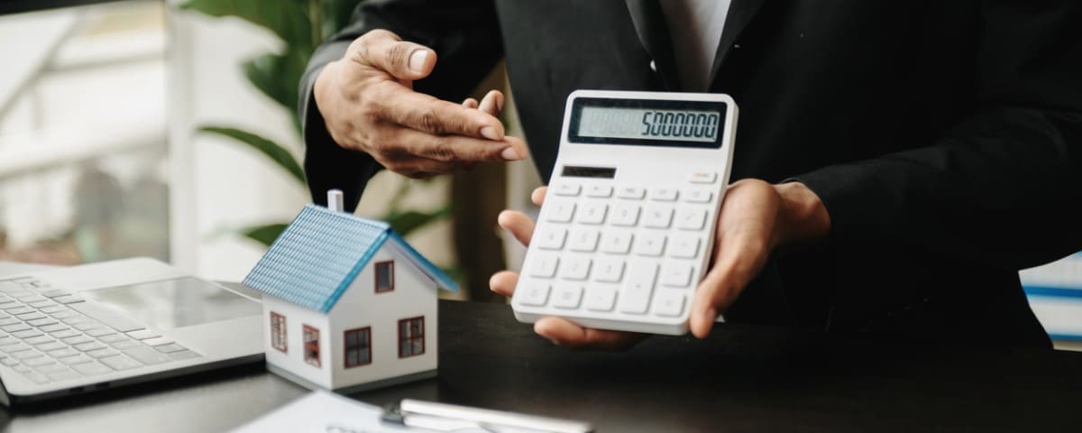 Mains d'un vendeur sur une petite maison