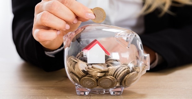 Pièces et mini maison dans une tirelire 