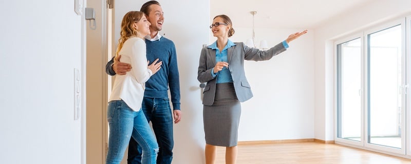 agent immobilier montrant une maison a des clients 