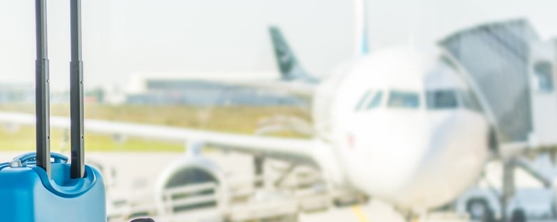 Bagage à main devant un avion