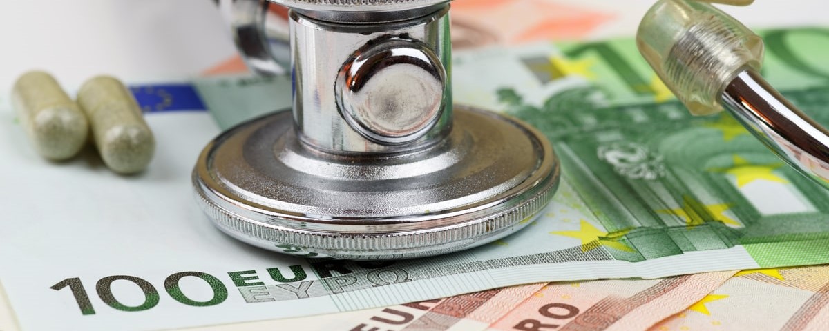 Stéthoscope et billets en euros sur fond blanc