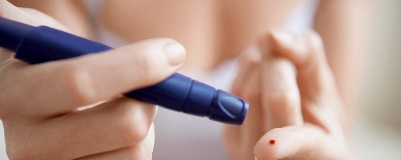  Une personne se pique le bout du doigt avec un auto piqueur pour prélever une goutte de sang afin de mesurer son taux de glycémie.