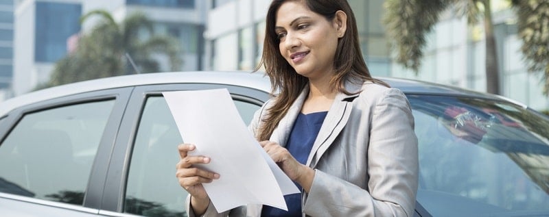 une femme en train de lire un document de franchise auto