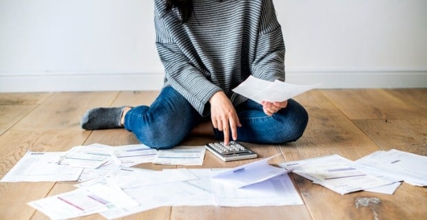Femme assise par terre entourée de documents